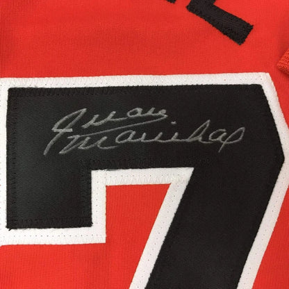 Red custom hockey jersey with black and white embroidered number 7 and signature patch from professional sports league