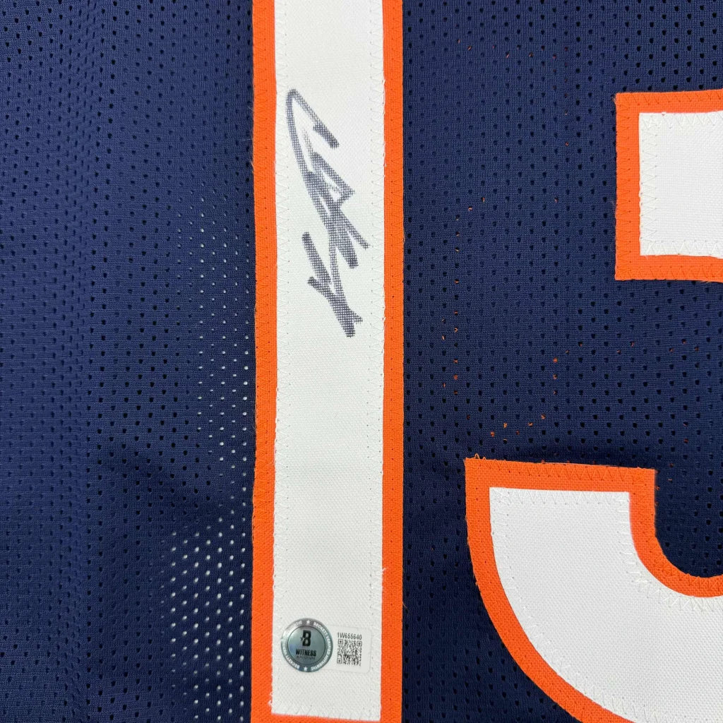 Navy blue professional sports league jersey with orange and white accents and signature