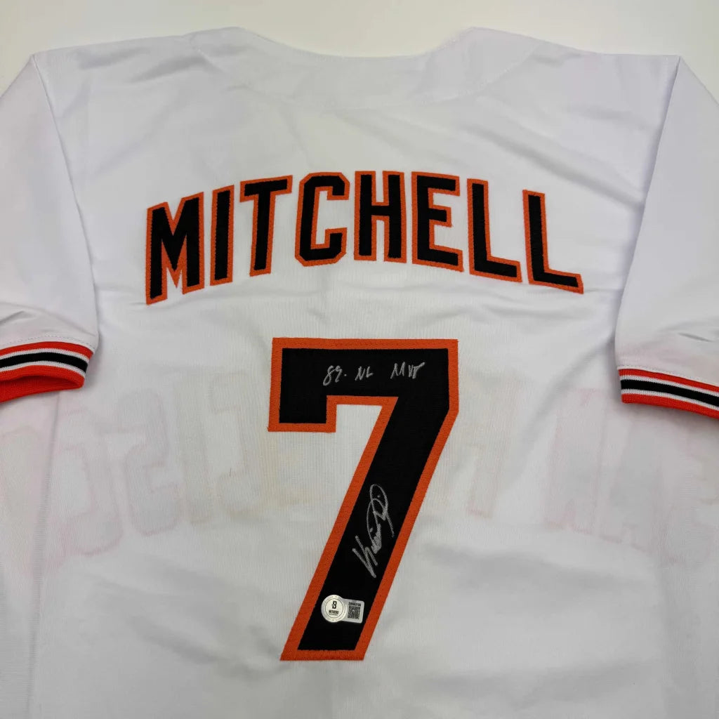 Back of a white autographed kevin mitchell 89 mvp baseball jersey with black and orange lettering and striped cuffs for professional sports league fans