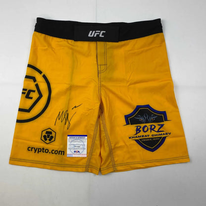 Yellow UFC fight shorts with signatures and logos, authentic and ready to wear