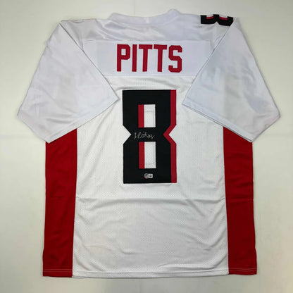 Back of autographed kyle pitts atlanta white football custom jersey with red black accents from professional sports league