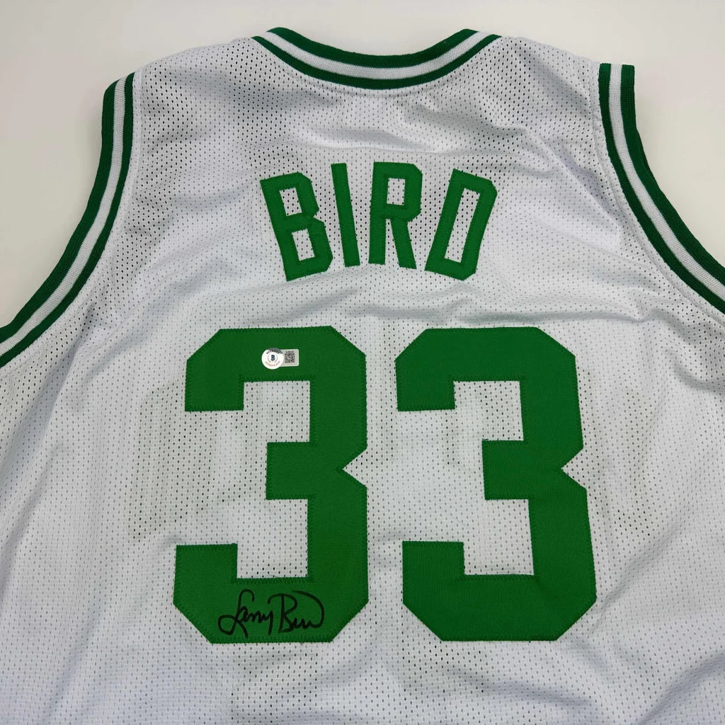 White basketball jersey with green trim and signature from professional sports league