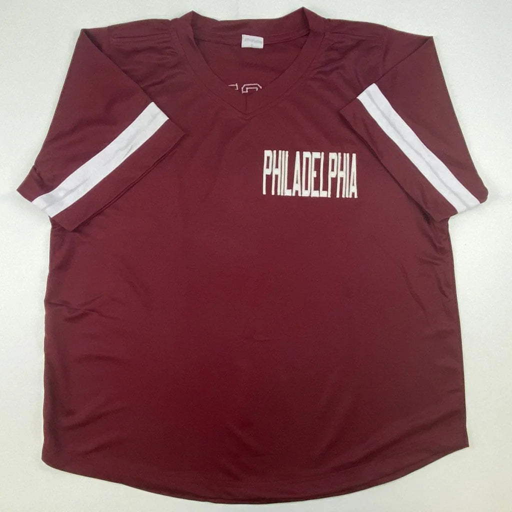 Maroon short-sleeved V-neck shirt with white stripes, perfect for professional sports fans