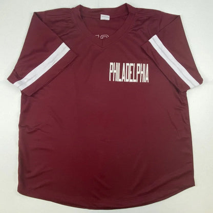 Maroon short-sleeved V-neck shirt with white stripes, perfect for professional sports fans