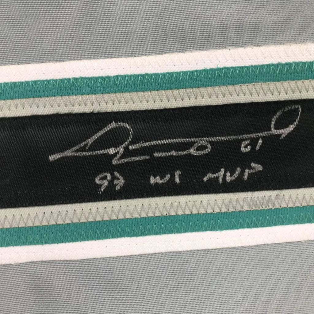 Black label with white signature and hebrew text stitched on striped gray teal white fabric of custom professional sports jersey