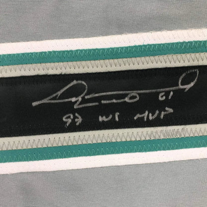 Black label with white signature and hebrew text stitched on striped gray teal white fabric of custom professional sports jersey