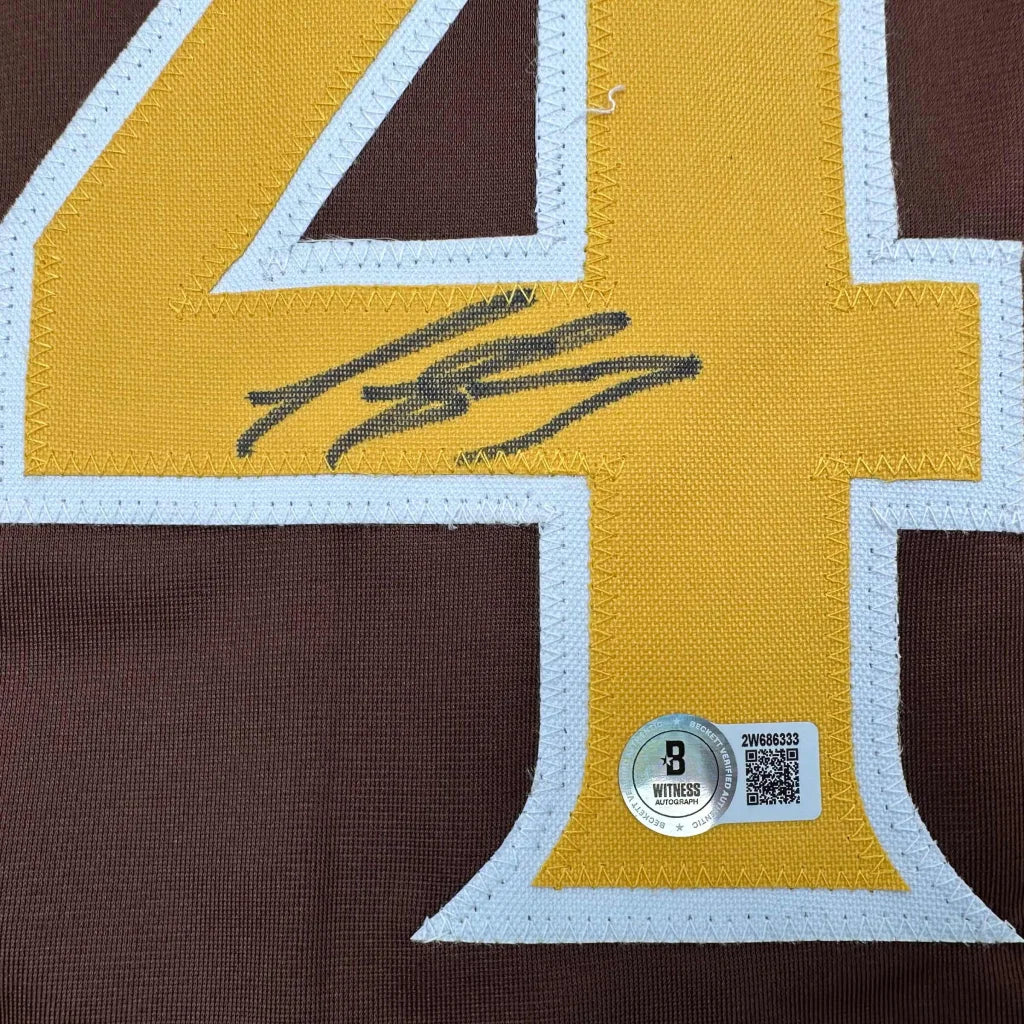 Brown and gold custom jersey signed by a professional sports league star with authentication sticker