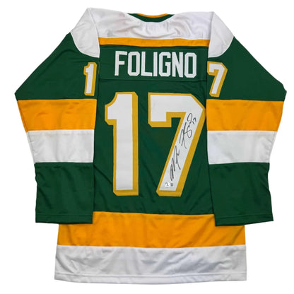 Back of a green and gold professional sports custom jersey with white accents autographed by marcus foligno number 17
