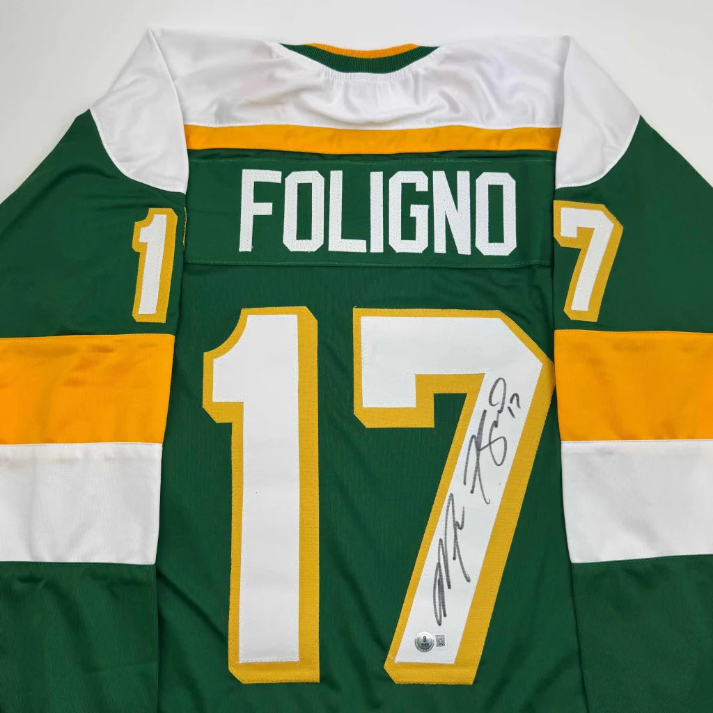 Back of a green and yellow autographed marcus foligno custom jersey with white lettering for professional sports league use
