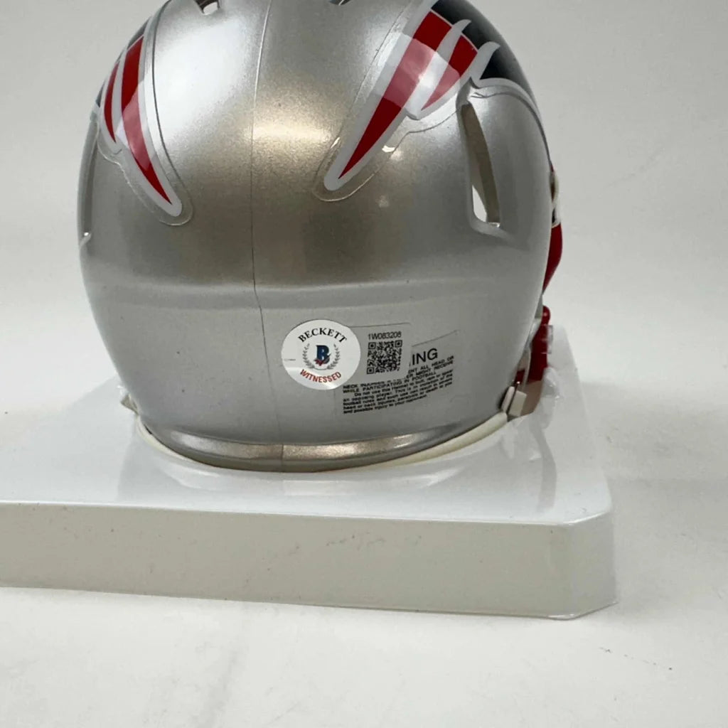 Silver New England Patriots mini helmet with red, white, and blue stripes in display case