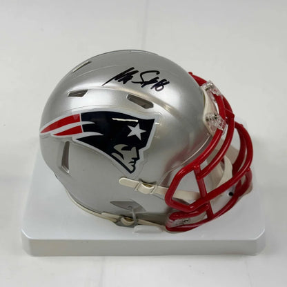 Silver New England Patriots mini football helmet with red facemask in display case