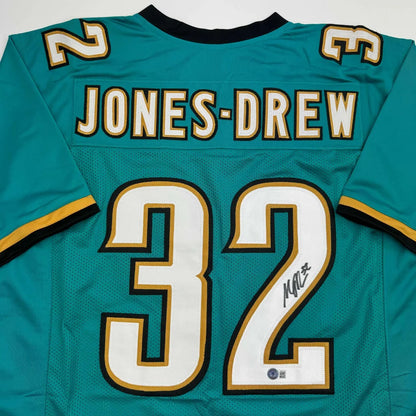 Autographed Teal American football jersey with gold and white accents for professional sports league