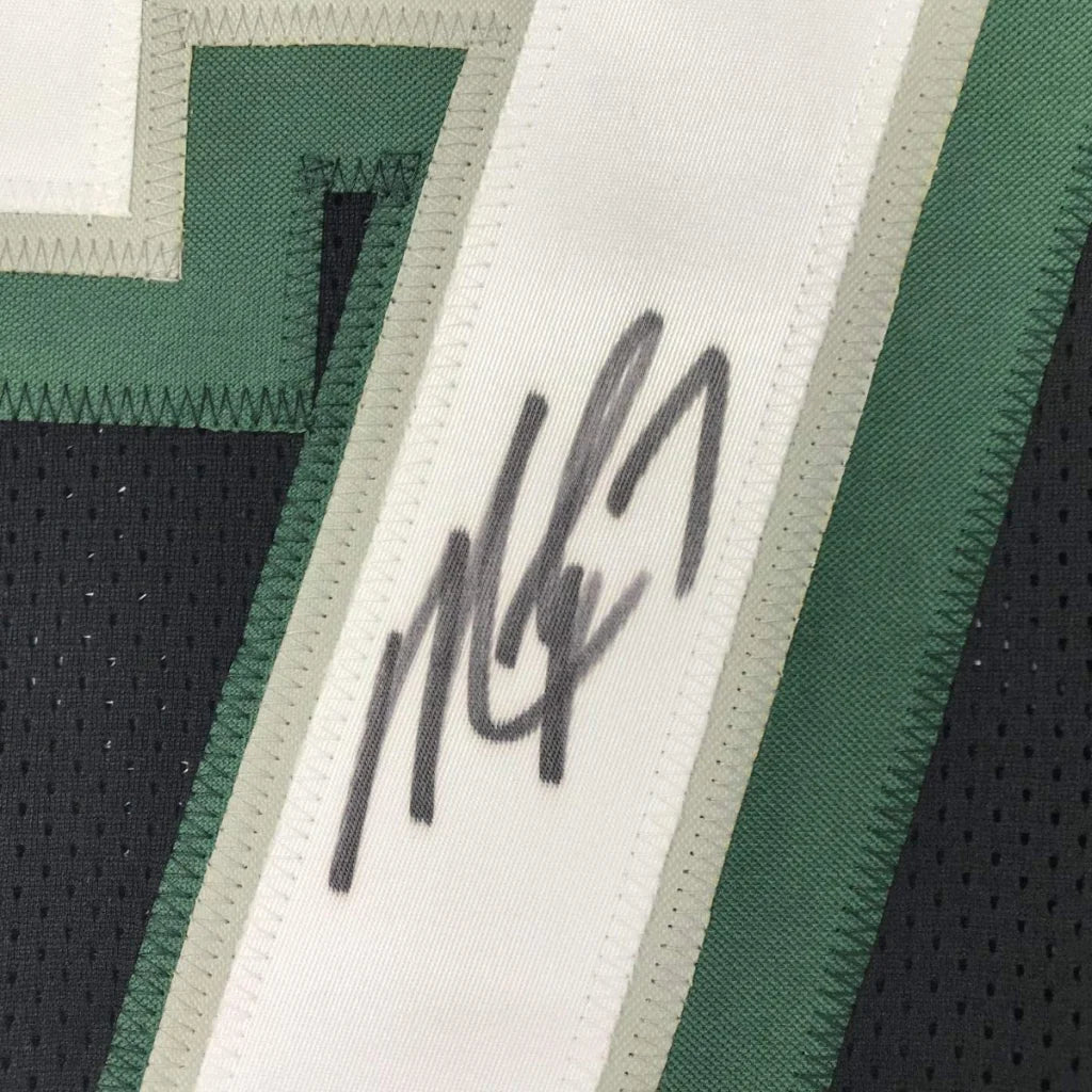 Autographed dark green and white Michael Vick professional sports league jersey collectible