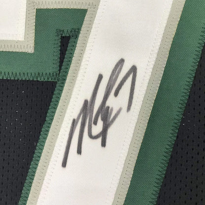 Autographed dark green and white Michael Vick professional sports league jersey collectible