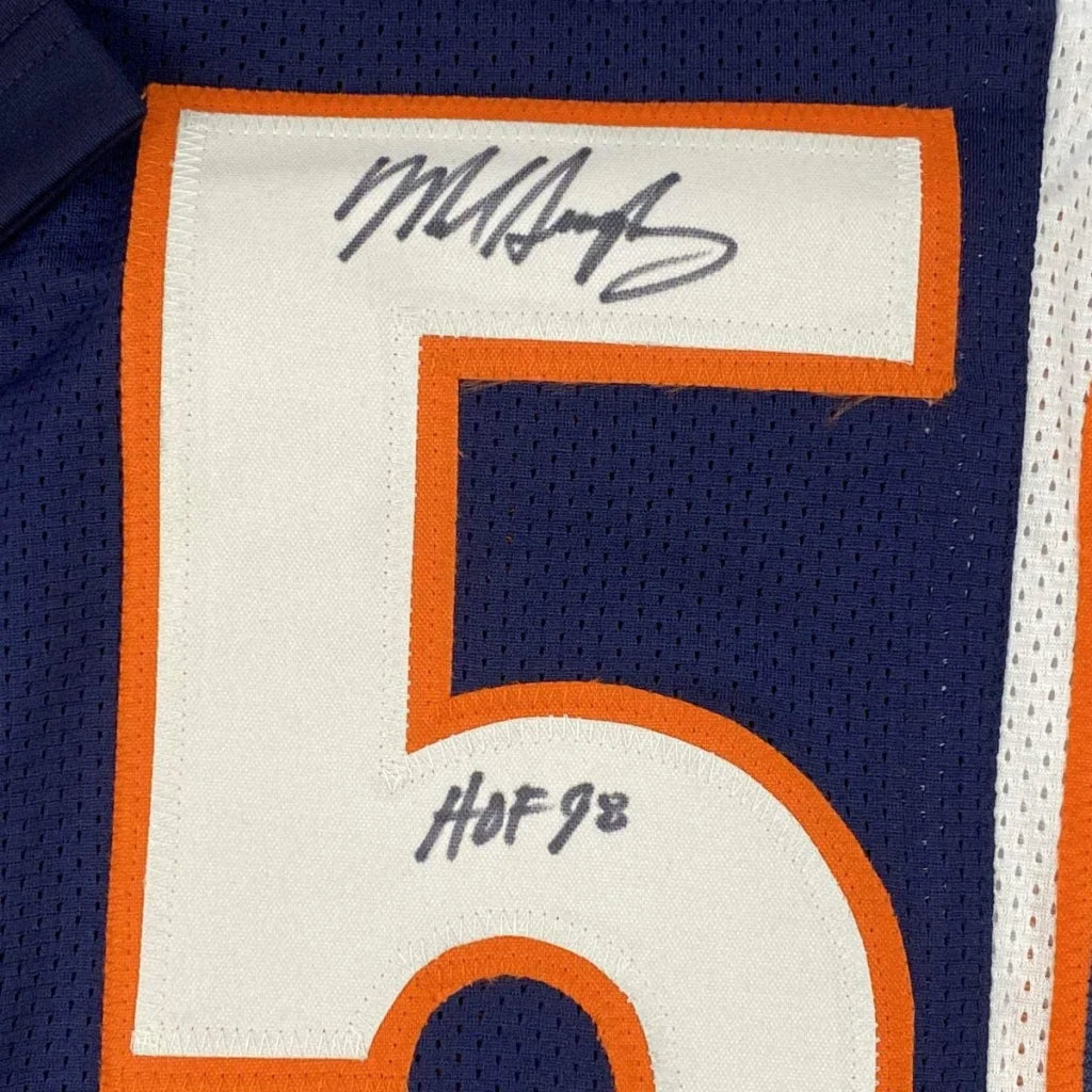 A navy blue custom football jersey with a white number 5 outlined in orange featuring Mike Singletary autograph hof 98 patch for professional sports league fans