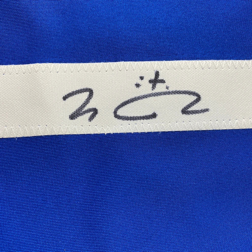 Blue fabric with white stitched ribbon from a custom jersey in professional sports league