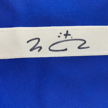Blue fabric with white stitched ribbon from a custom jersey in professional sports league