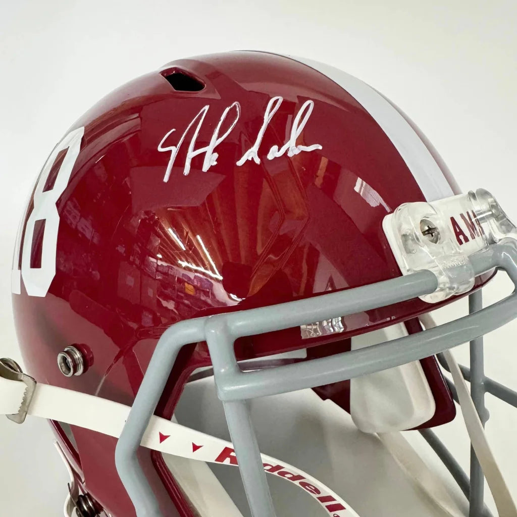 Glossy crimson autographed Alabama Crimson Tide full size college football helmet with white number 8 and gray faceguard