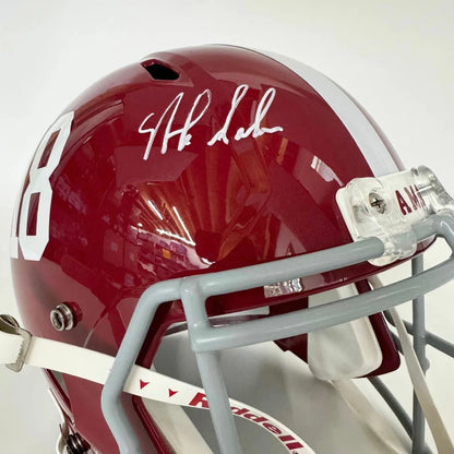 Glossy crimson autographed Alabama Crimson Tide full size college football helmet with white number 8 and gray faceguard
