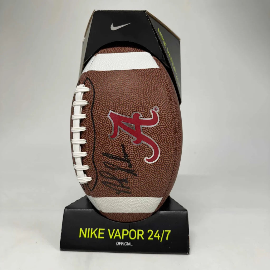 Brown leather football with white laces, A logo, signature on a black stand