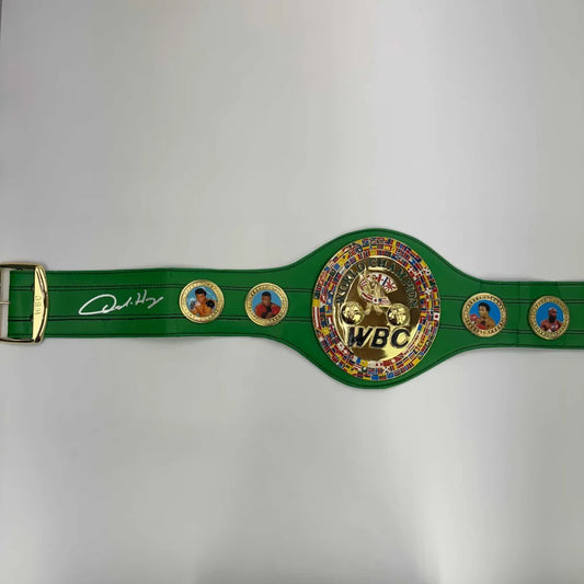 Green WBC boxing championship belt with a gold buckle and boxer portraits