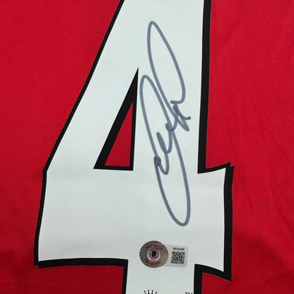 Red sports jersey with white number 4 and black autograph from professional sports league