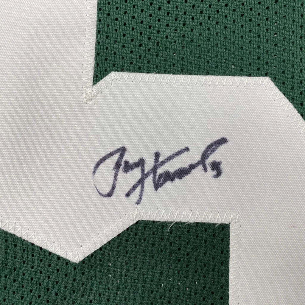 A white fabric patch with jay hannas signature stitched on green perforated mesh on a custom jersey for professional sports league