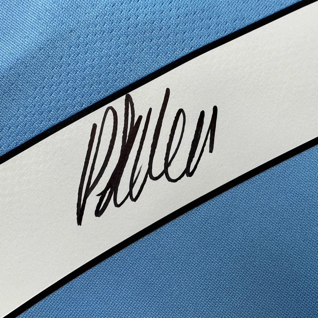 Light blue Manchester City jersey with white stripe and black autograph, third party authentication