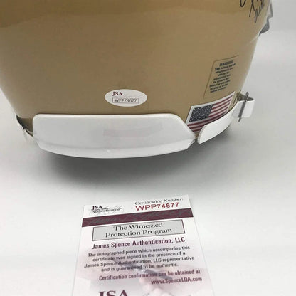 Gold-colored football helmet with white chin strap and third party authentication sticker