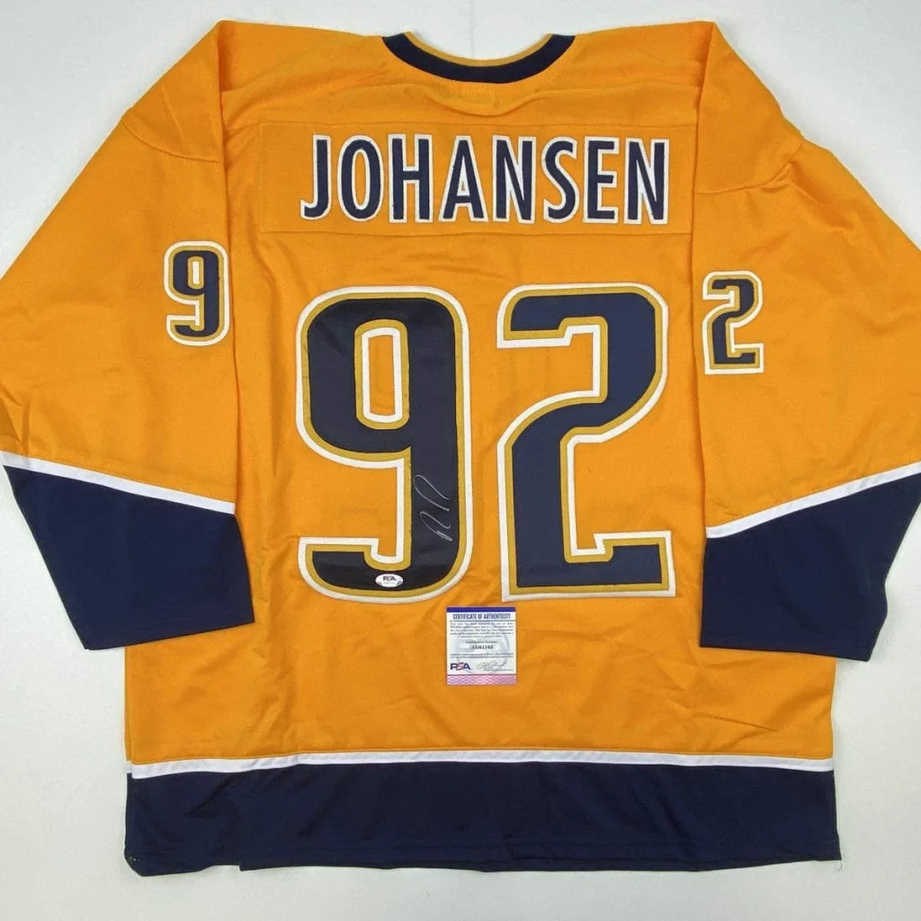 Back of an autographed vibrant orange ryan johansen custom jersey with navy blue and white accents for professional sports league