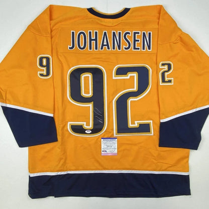 Back of an autographed vibrant orange ryan johansen custom jersey with navy blue and white accents for professional sports league