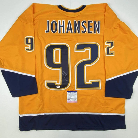 Back of an autographed vibrant orange ryan johansen custom jersey with navy blue and white accents for professional sports league