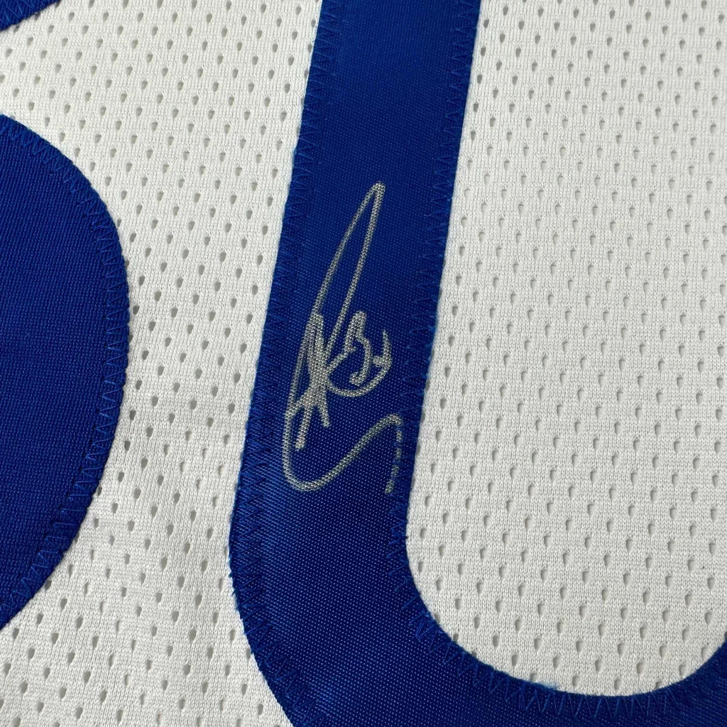 White athletic jersey with blue number 0 and silver autograph from professional sports league