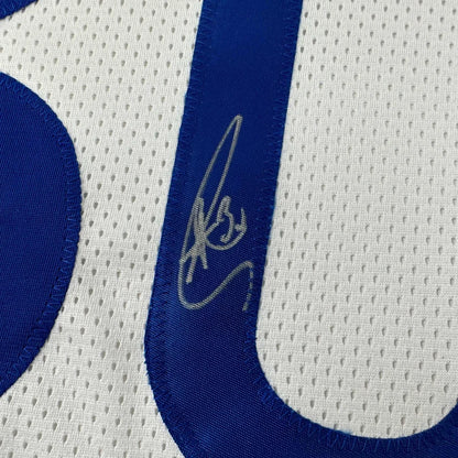 White athletic jersey with blue number 0 and silver autograph from professional sports league