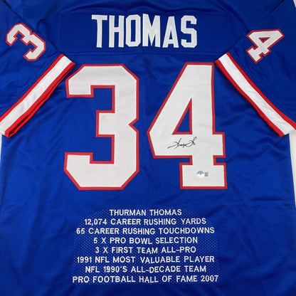 Back side of a blue autographed thurman thomas football jersey with white and red lettering number 34 in professional sports league style