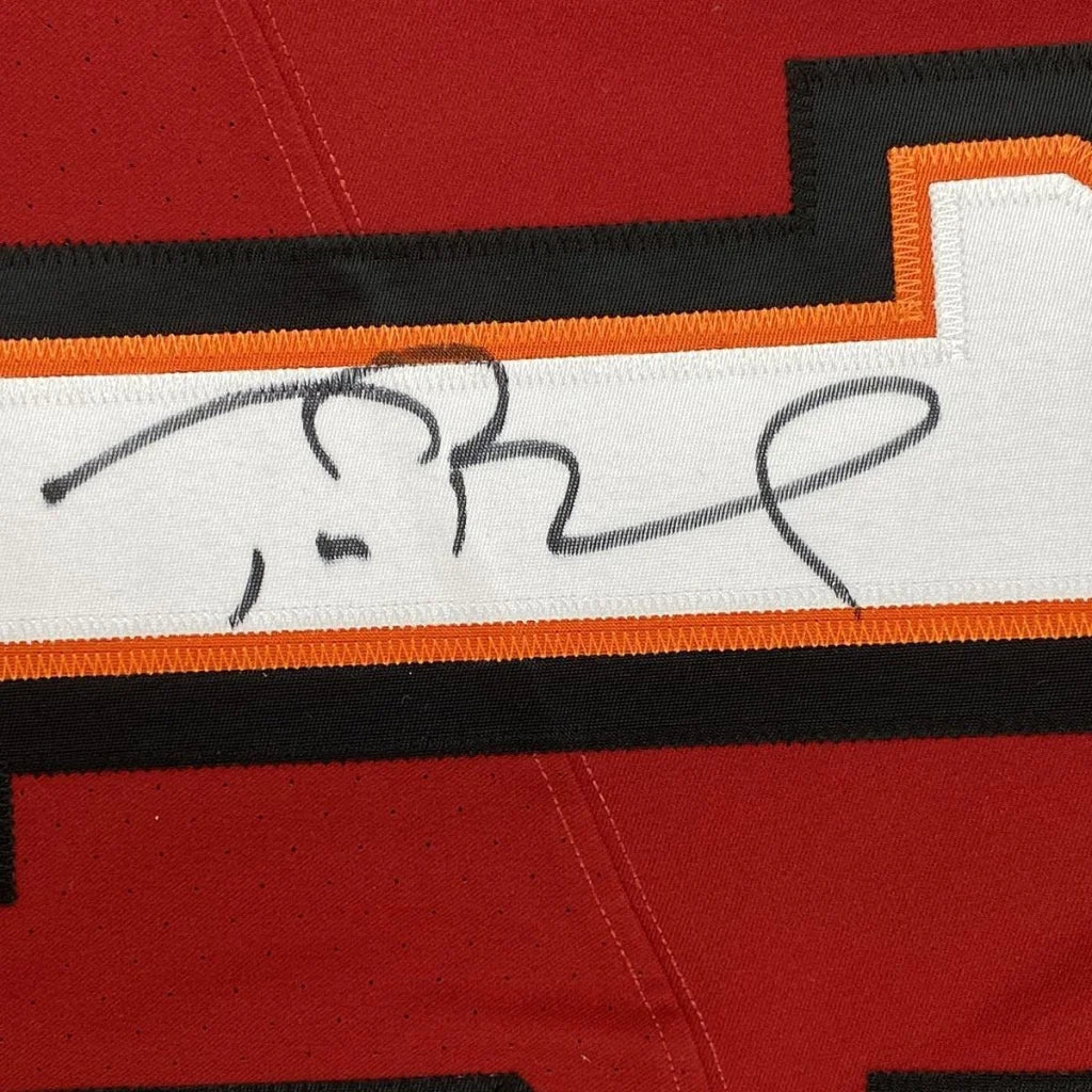 Red Buccaneers sports jersey with black and orange stripe and third party authentication