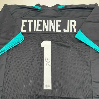 Autographed Travis Etienne Jr. custom Jacksonville black jersey with teal accents