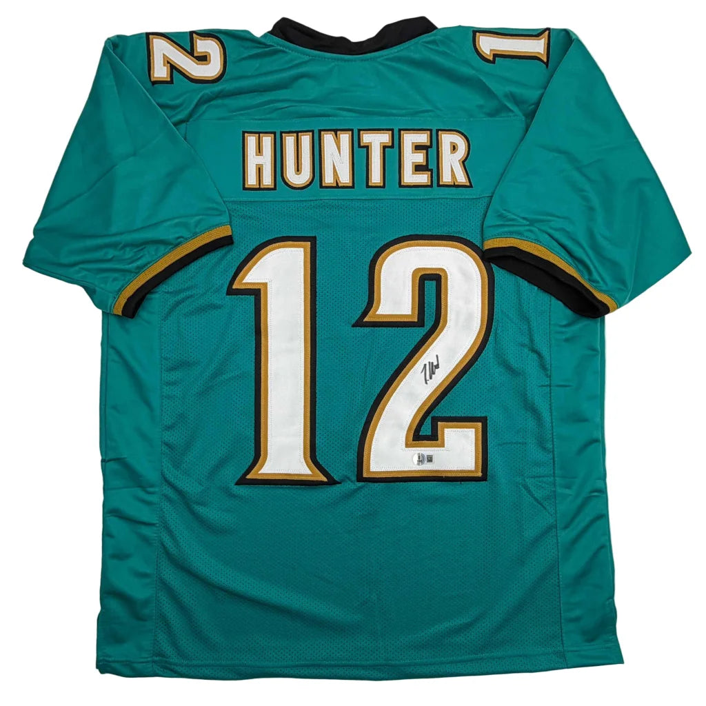 Autographed Travis Hunter Jacksonville Teal Retro Football Jersey Beckett BAS COA | Hall of Fame Sports Memorabilia | vintageantiquesgifts.com