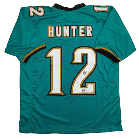 Autographed Travis Hunter Jacksonville Teal Retro Football Jersey Beckett BAS COA | Hall of Fame Sports Memorabilia | vintageantiquesgifts.com