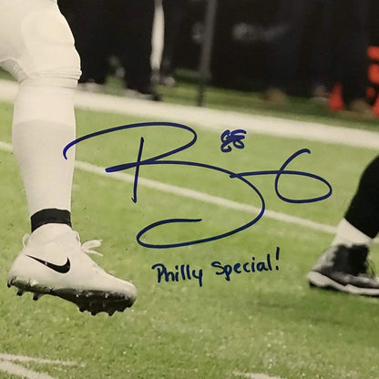 White Nike football cleat with black swoosh beside autographed Trey Burton Philly Special Eagles photo