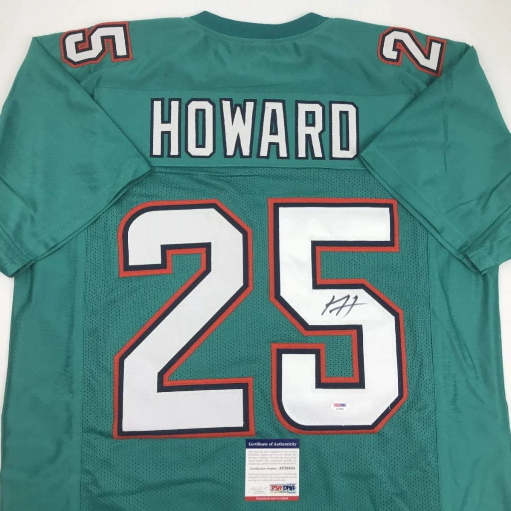 Image of the back side of a teal miami dolphins custom jersey with white and orange 25 howard numerals and autograph