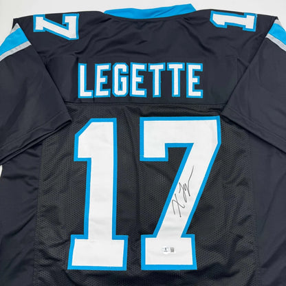 Back side of custom autographed black and blue Carolina panthers football jersey with white number 17 legette for professional sports league