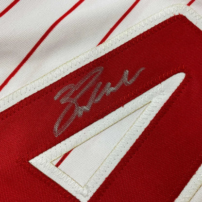 White professional sports league jersey with red pinstripes, number 4, and silver autograph