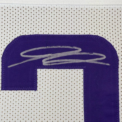 White football jersey with purple number and silver autograph ready to hang