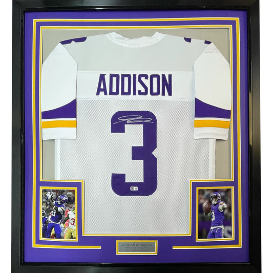 Autographed white football jersey with purple accents and player photos for hanging