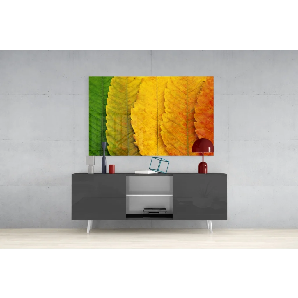 Vibrant autumn leaves wall art canvas print in green to yellow orange gradient above gray console