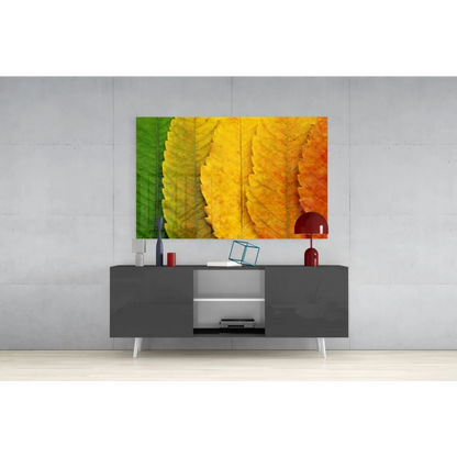 Vibrant autumn leaves wall art canvas print in green to yellow orange gradient above gray console