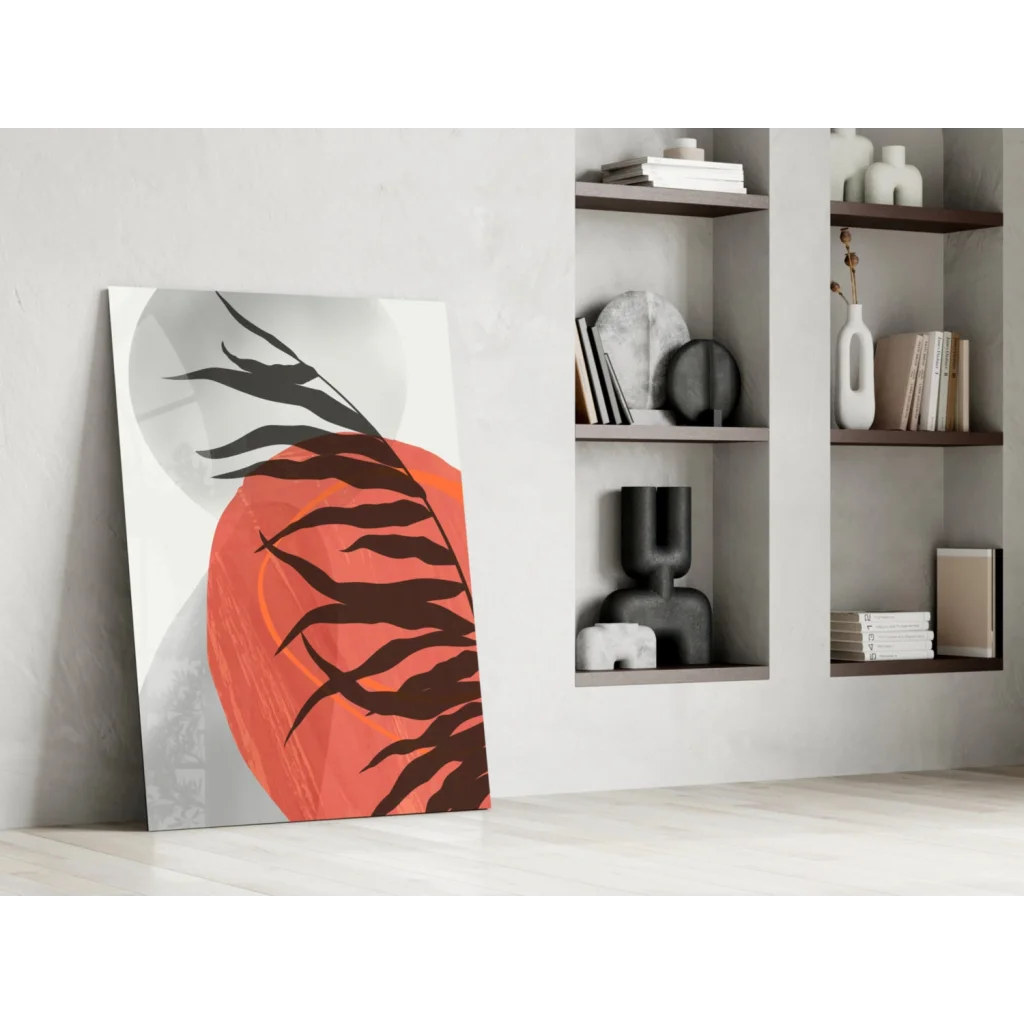 Bold black leaf silhouettes on vibrant orange glass wall art with gray gradients