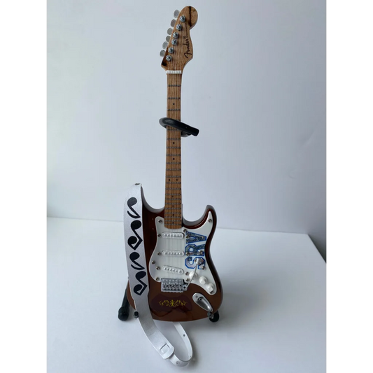 Axe Heaven mini guitar strap with Stevie Ray Vaughan musical note design on brown Fender Stratocaster