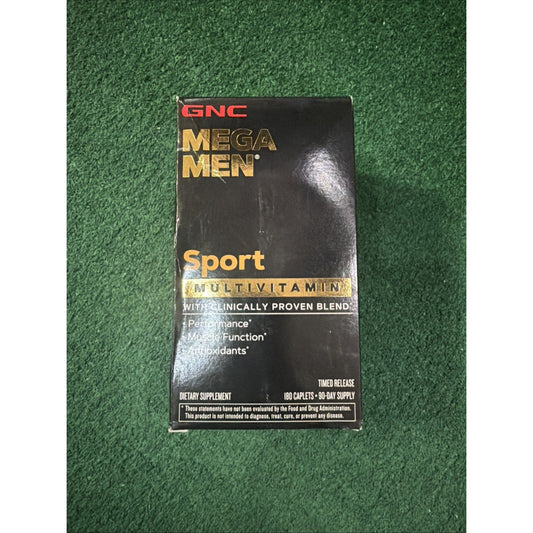 GNC Mega Men Sport Multivitamin black box with gold text displayed flat on green textured surface, front packaging view.
